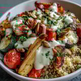Overhead view of a healthy Roasted Vegetable Quinoa Bowl topped with fresh parsley and toasted pumpkin seeds, perfect for a vegan dinner.