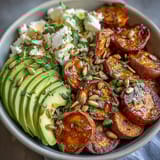 Golden roasted sweet potato cubes with crispy edges sit beside creamy avocado slices and cottage cheese in this vibrant Hot Honey Sweet Potato Bowl.