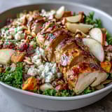 Wholesome harvest bowl featuring wild rice, tender chicken, roasted sweet potatoes, crisp apples, and creamy goat cheese with crunchy almonds.  