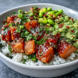 Vibrant salmon poke bowl brimming with edamame, avocado, and fresh veggies.