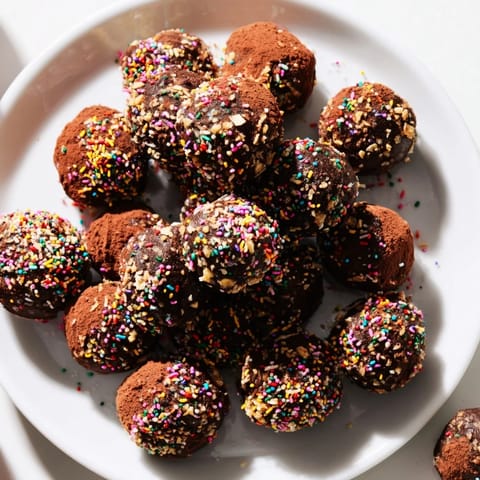 Beautiful chocolate truffles, a decadent treat rolled in sprinkles, perfect for any special occasion.