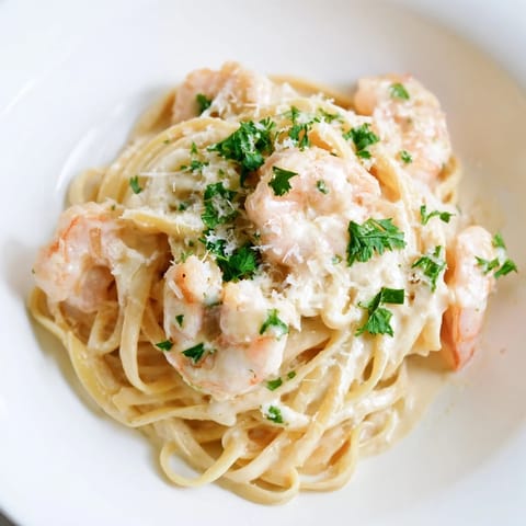 Freshly cooked linguine twirled with succulent shrimp and coated in a rich, creamy garlic Parmesan sauce, garnished with parsley.