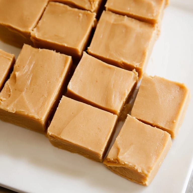 Close-up of freshly cut peanut butter fudge, offering a glimpse of the delicious, creamy texture.