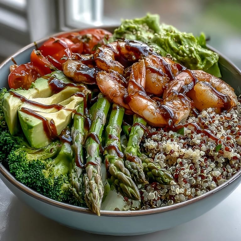 Close-up on the creamy sliced avocado and crisp red cabbage in a nourishing Rainbow Vegetable Detox Bowl, featuring juicy shrimp and blanched green vegetables over a bed of fluffy quinoa.