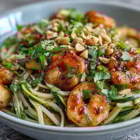 Colorful Asian Noodle Bowl topped with peanuts and cilantro, ready to serve with lime wedges for a fresh squeeze.
